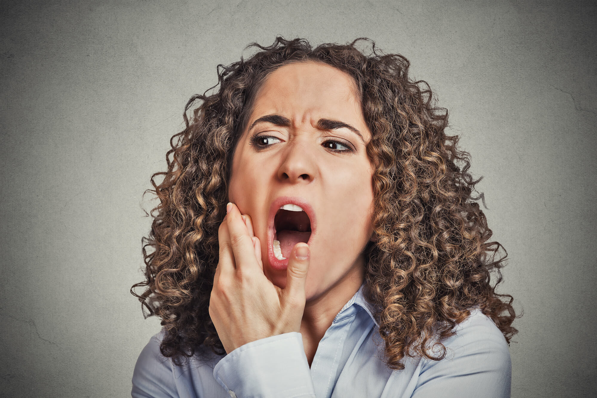 woman in pain because of Impacted wisdom teeth 76210